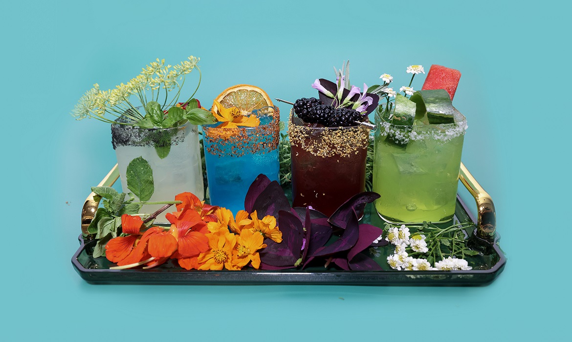 Four colorful cocktails with green-blue background 